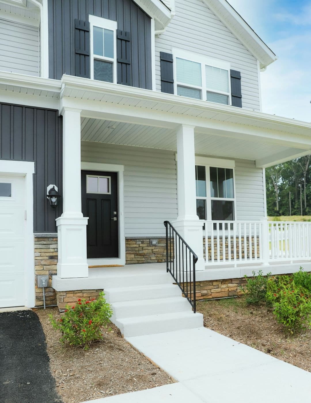 A house with sections of white horizontal and dark gray vertical siding.