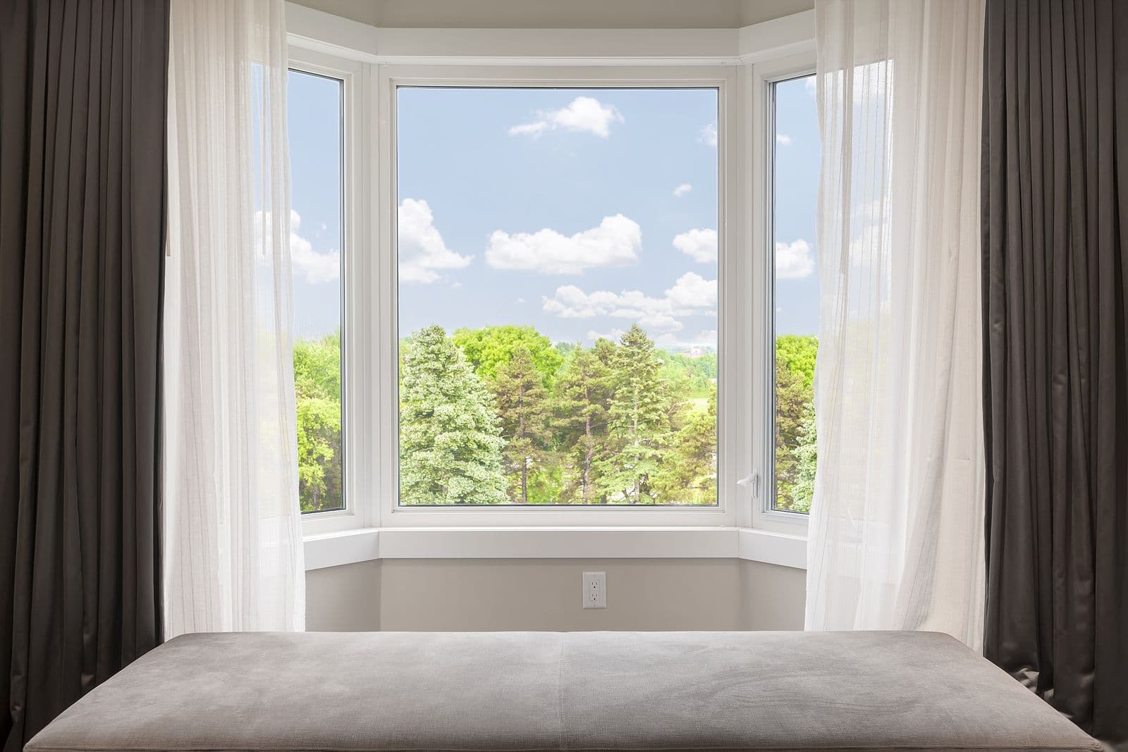 Bay window with drapes and curtains.