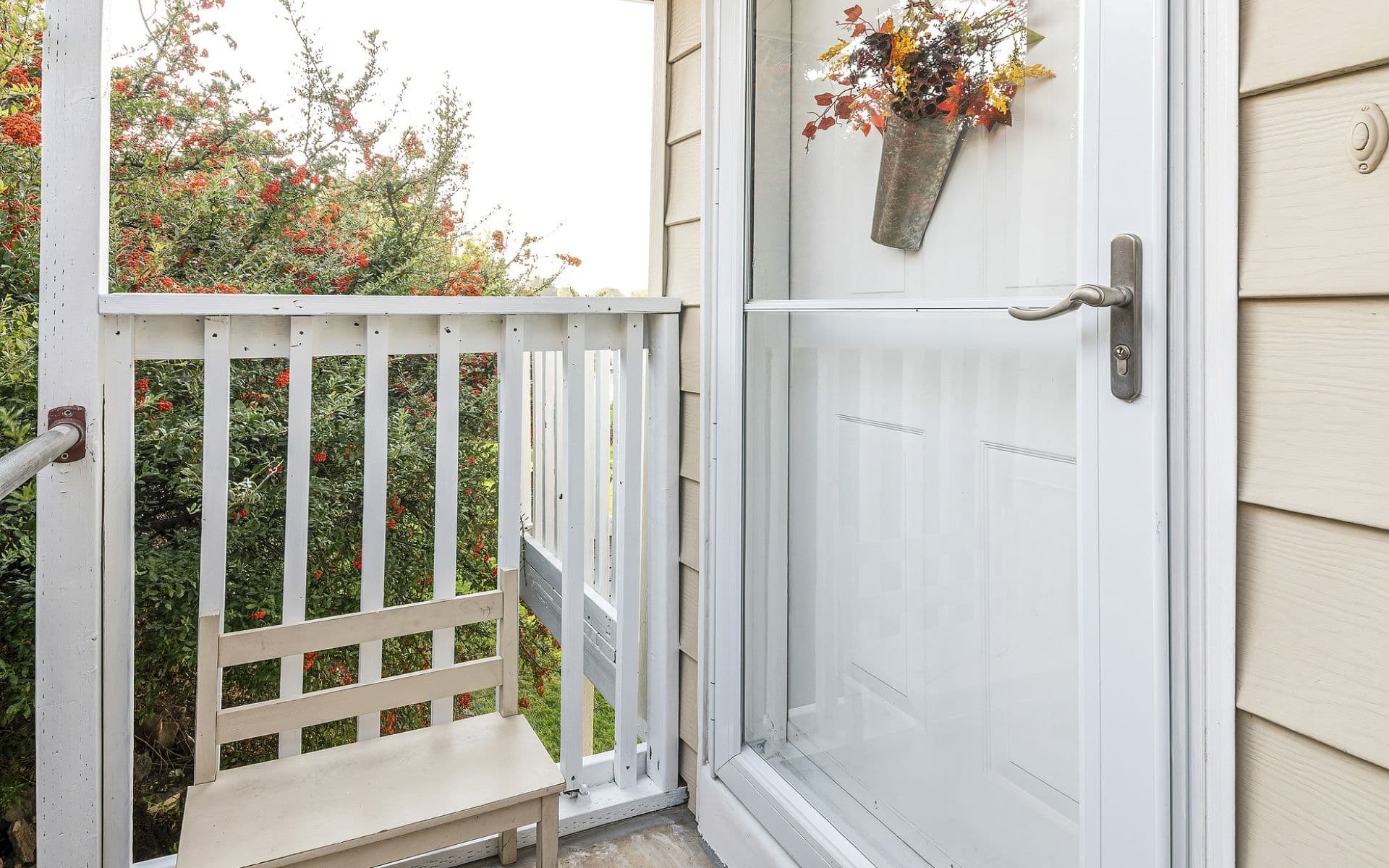 A house with a white front entry door and a glass storm door.