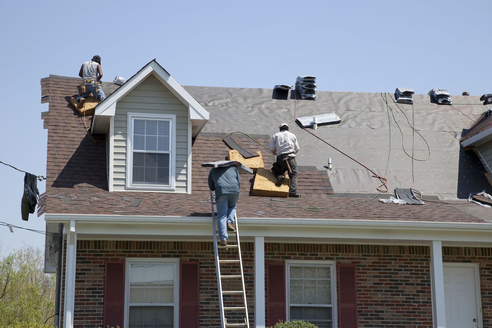 Workers install new residential roofing.