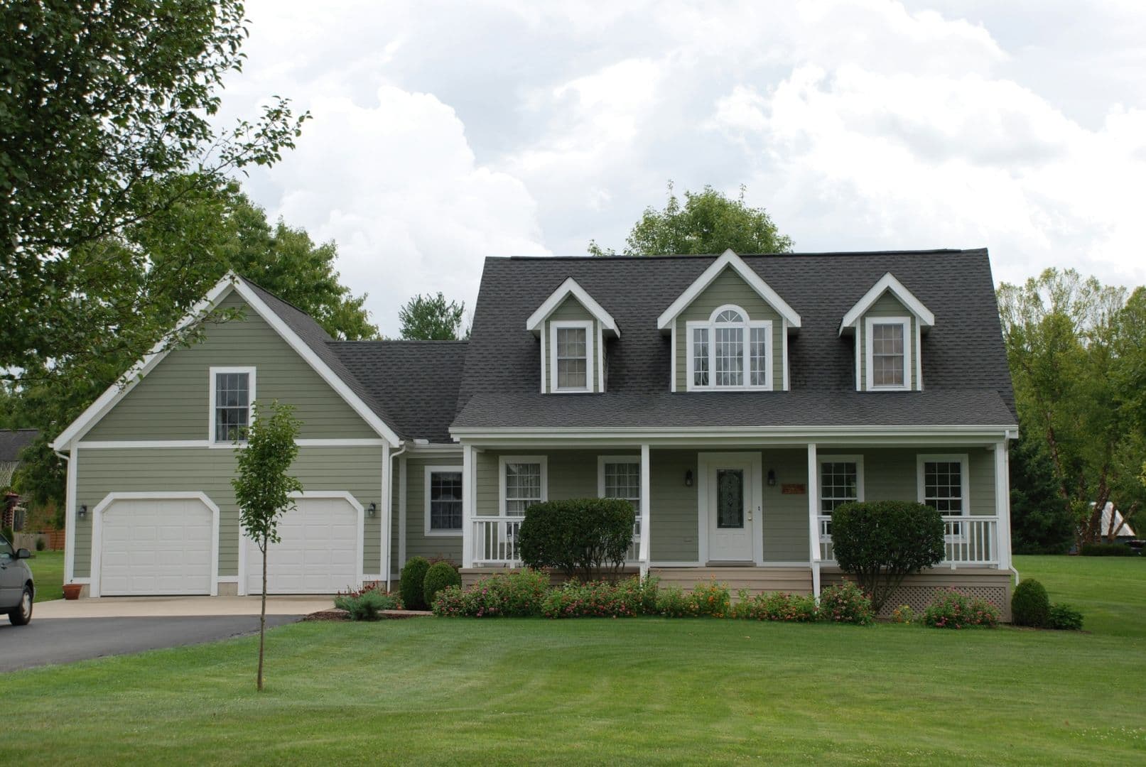A light green house with white trim and a gray roof.
