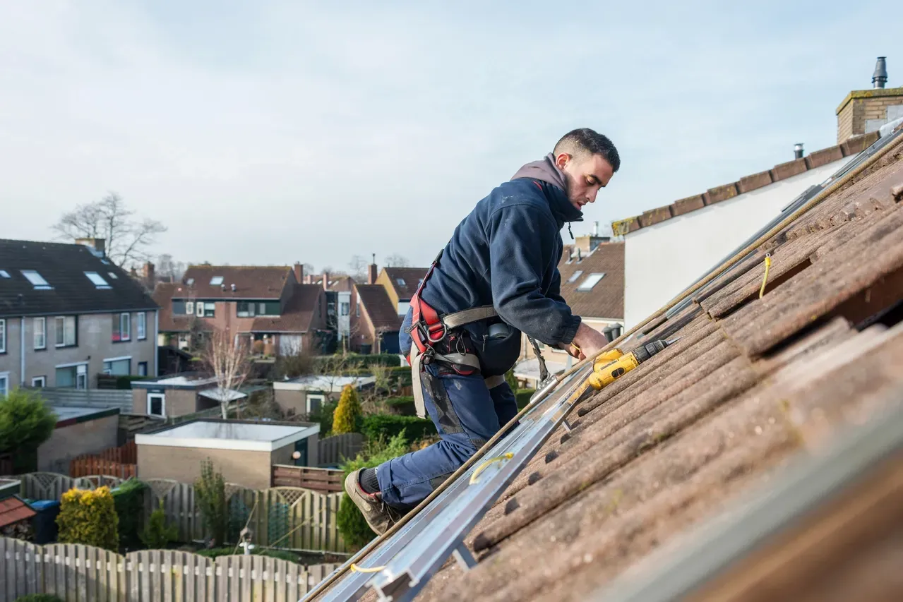 A worker installs roofing.